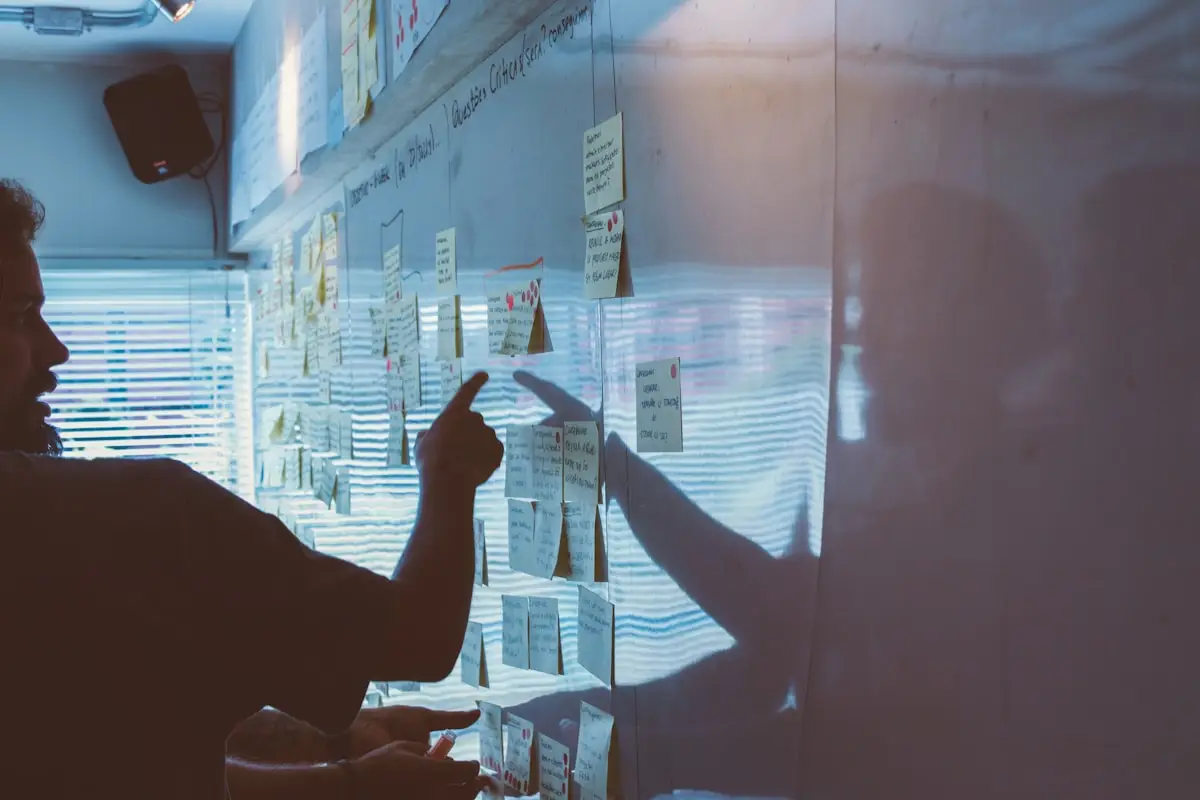 Strategist organizing brand ideas on a wall of notes