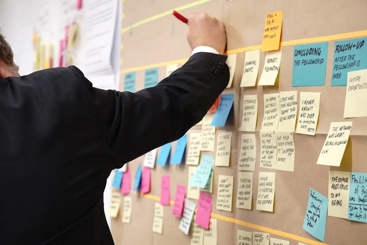 Brand strategist organizing a wall of colorful planning notes