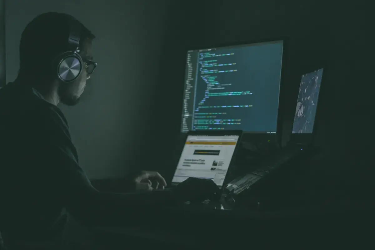 Software developer working across multiple code displays
